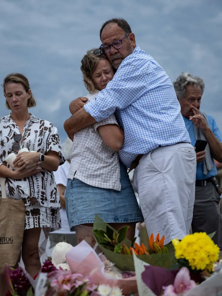 People embrace at the floral tributes for the victims of the deadly terror attack.
