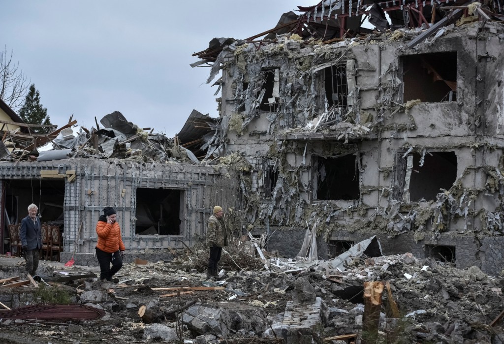People sift through the debris of a home struck by a Russian missile on Dec. 6, 2025.