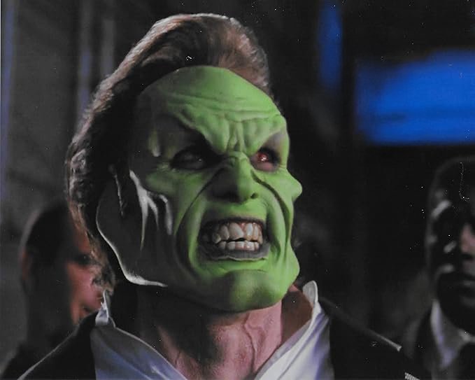 Peter Greene wearing The Mask, his face is green and grotesque.