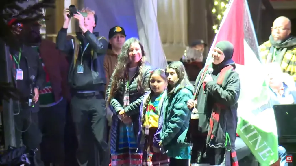 One of the speakers at the tree lighting ceremony was seen holding a Palestinian flag and leading the crowd in a “free Palestine” chant.