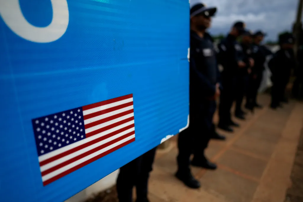 Police guard the entrance to the US embassy in Brasilia, Brazil, as protesters gather outside.