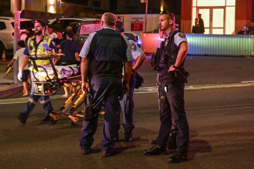 Police standing on a road after a shooting incident at Bondi Beach in Sydney.