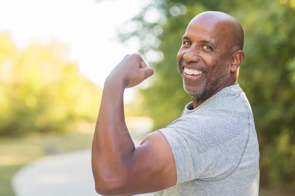 Mature African American man flexing his bicep.