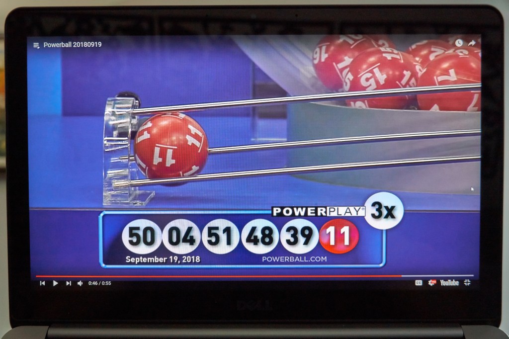 Powerball lottery winning numbers displayed on a laptop screen.
