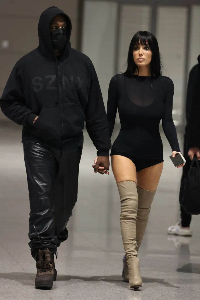 Kanye West and Bianca Censori holding hands at Seoul Airport.
