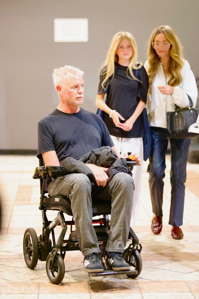 Eric Dane in a wheelchair with Rebecca Gayheart and Georgia Dean walking behind him.
