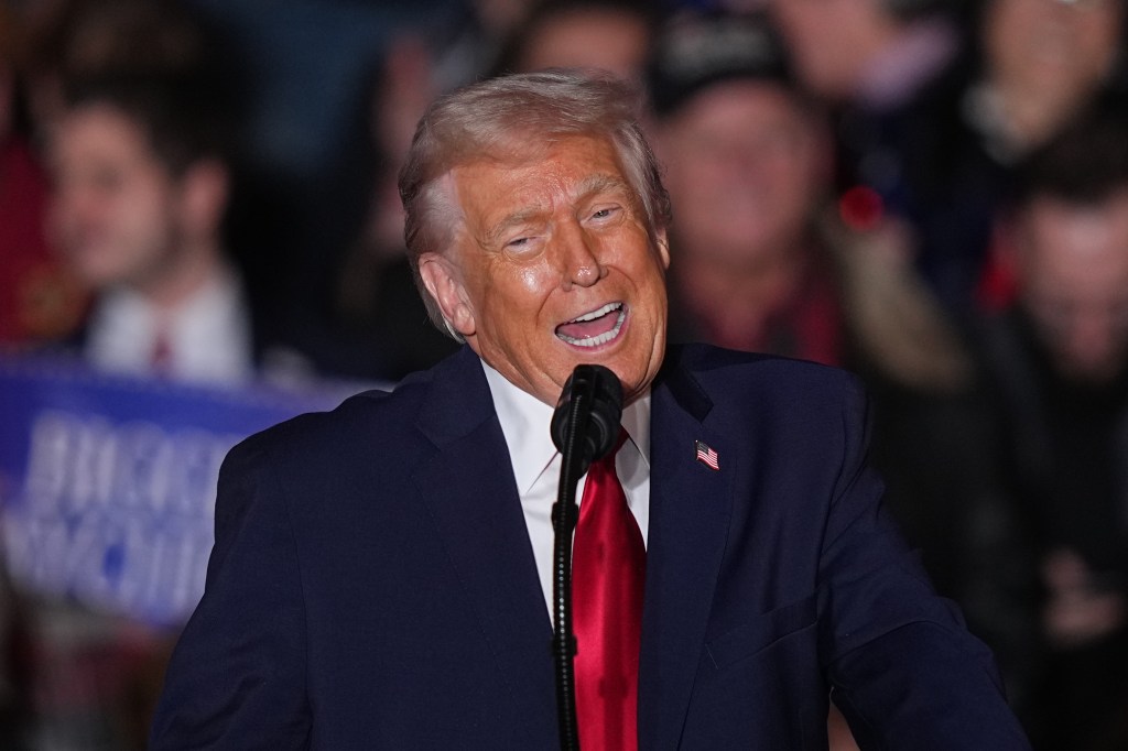 Donald Trump speaking at a podium with a microphone.