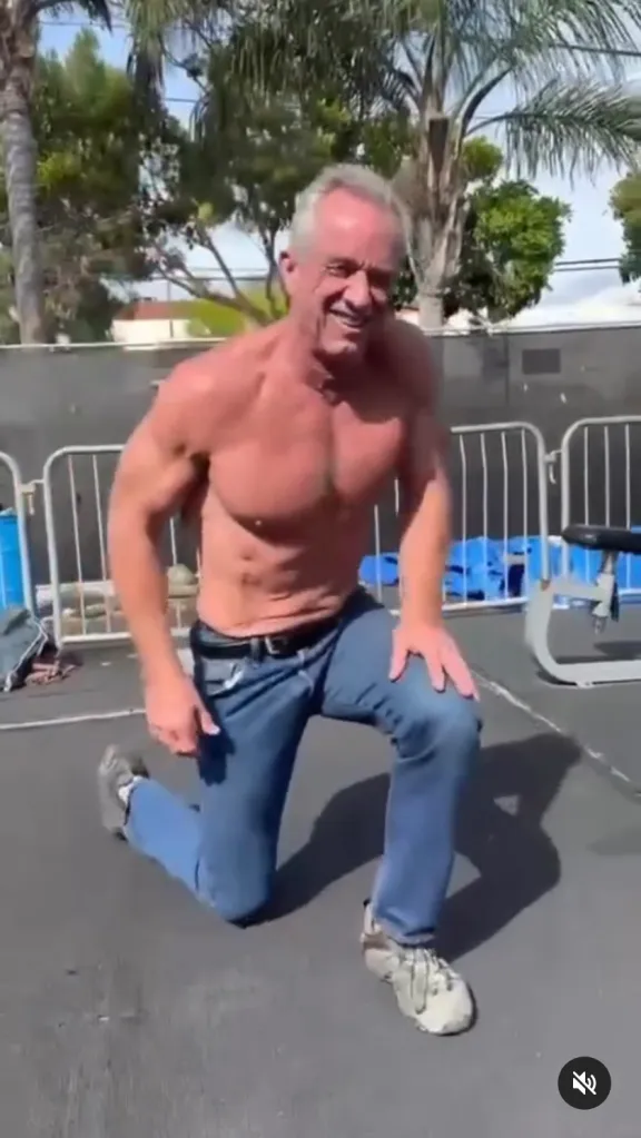 Robert F. Kennedy Jr. shirtless, kneeling on the ground, smiling.