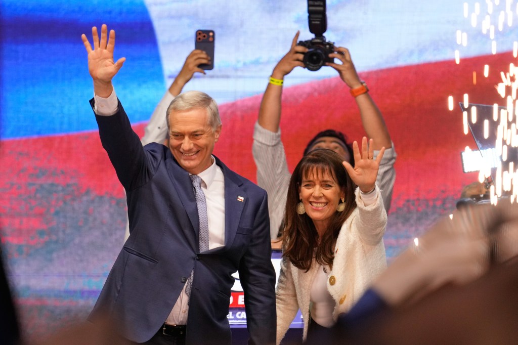 Presidential candidate Jose Antonio Kast and his wife Maria Pia Adriasola wave to supporters.