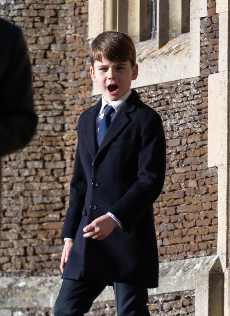 Prince Louis of Wales with his mouth open, wearing a dark coat and tie outside Sandringham Church.