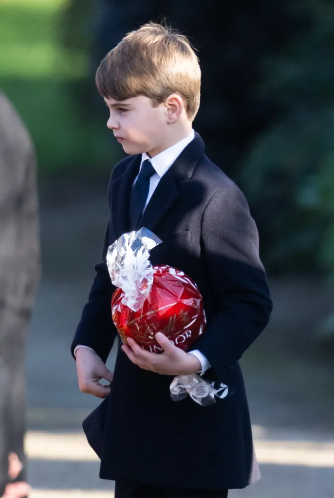 Prince Louis of Wales holding a red gift-wrapped present.