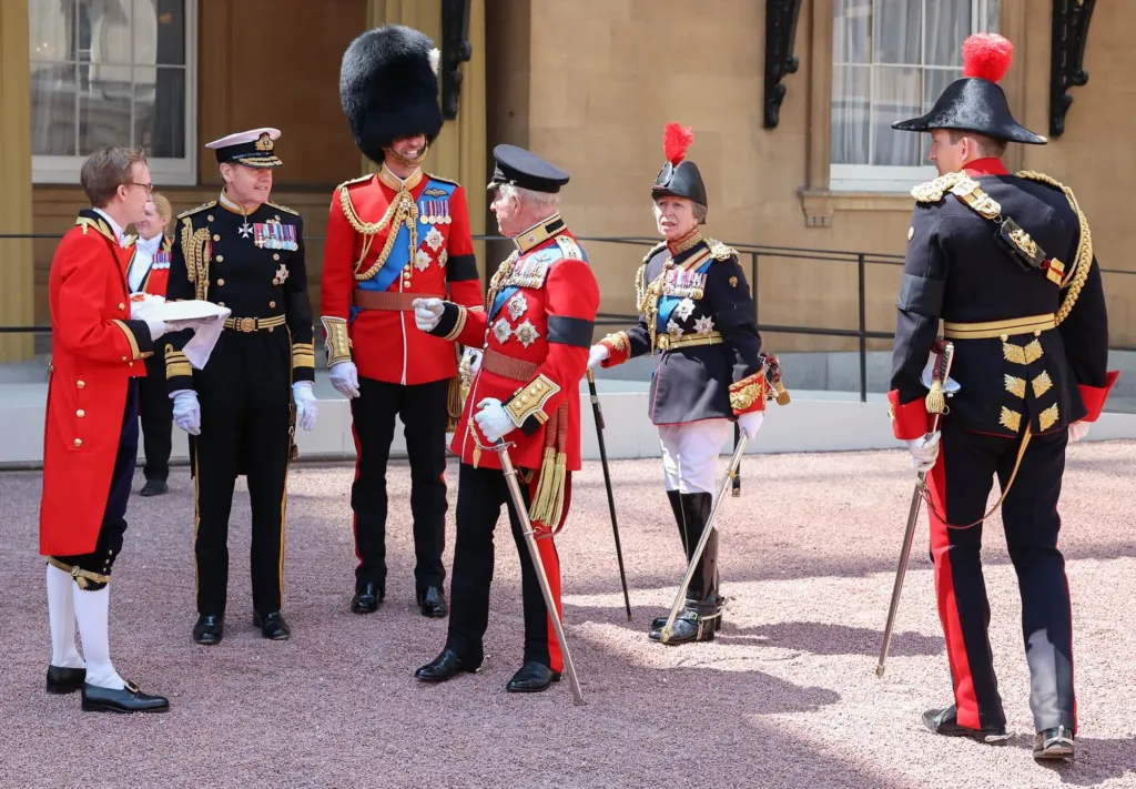 Prince William, King Charles, Princess Anne, and others in military attire at an outdoor event.