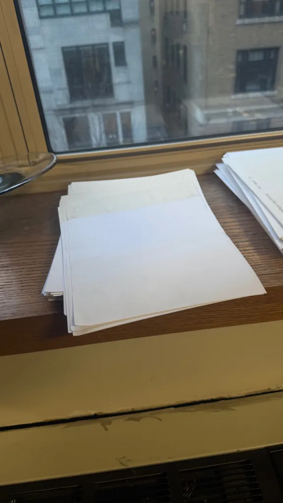 Stack of printing paper on a window sill.