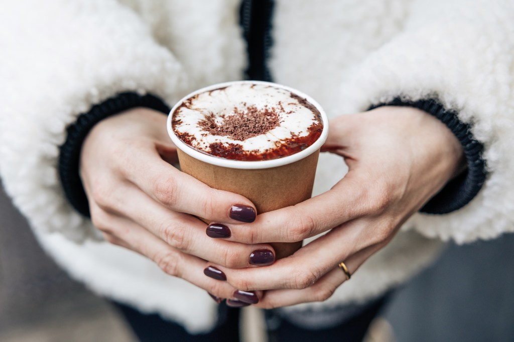 Rachel Brotman holding a cup of Caffe Panna's hot chocolate.