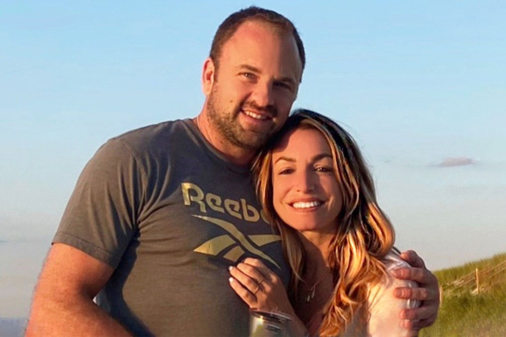 A man in a Reebok t-shirt with his arm around a smiling woman.
