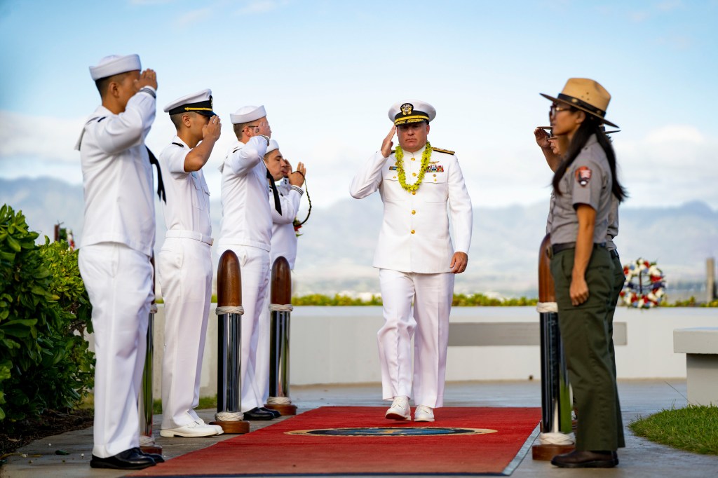 Rear Adm. Brad Collins, commander of Navy Region Hawaii, salutes as he departs after the 84th Pearl Harbor Remembrance Day ceremony.