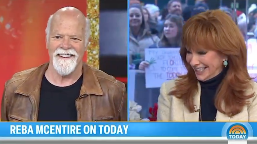 Reba McEntire smiling on a TV show screen, with a man next to her in split screen.
