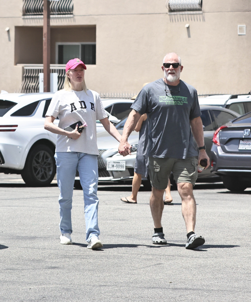 Erika Jayne and John McPhee holding hands.