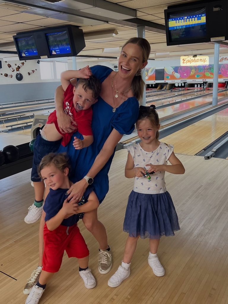 Meghan King poses with her three children at a bowling alley.