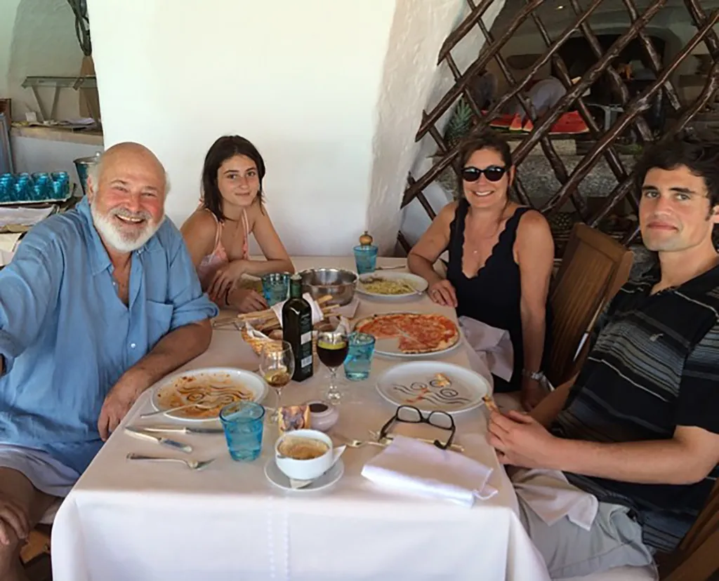 Rob Michele, Romy, and Nick Reiner seated around a table at a restaurant.