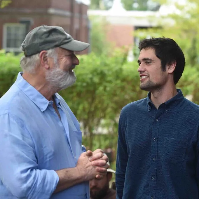 Rob Reiner and son Nick looking at each other and smiling.