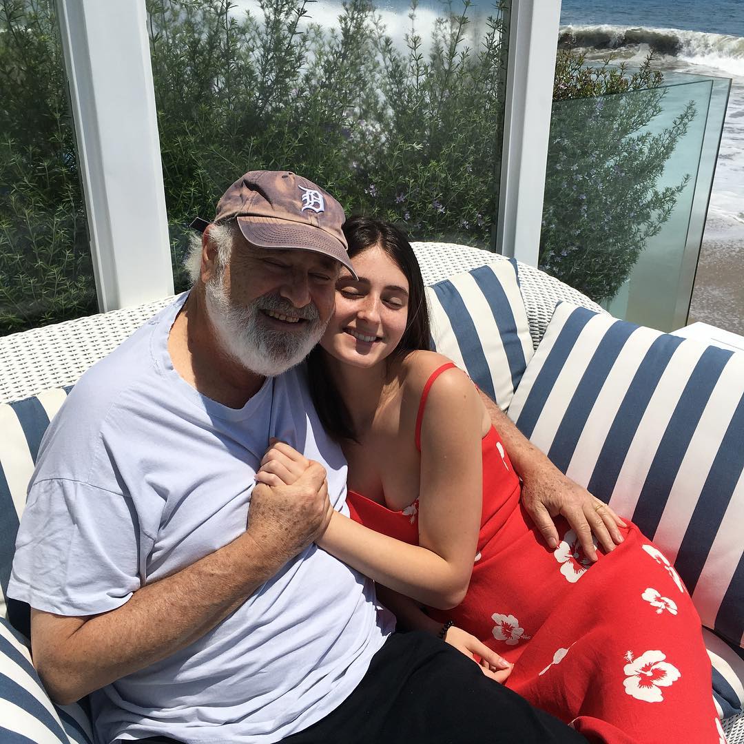 Rob and Romy Reiner embracing on a striped couch overlooking the ocean.