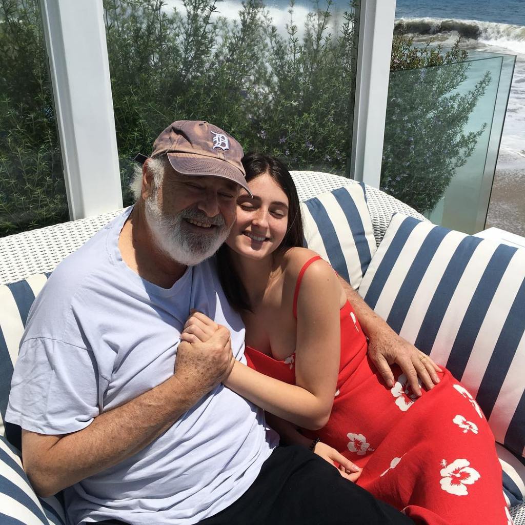 Rob Reiner and his wife Romy on a couch, with the ocean in the background.