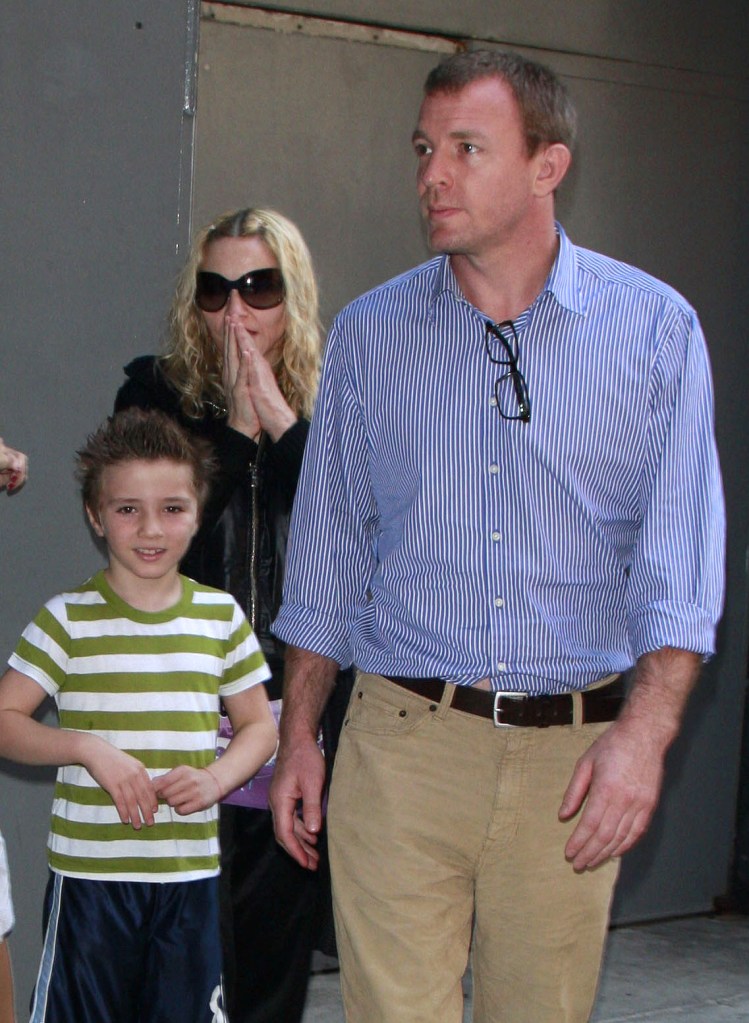 Madonna, Rocco Ritchie, and Guy Ritchie walking together.
