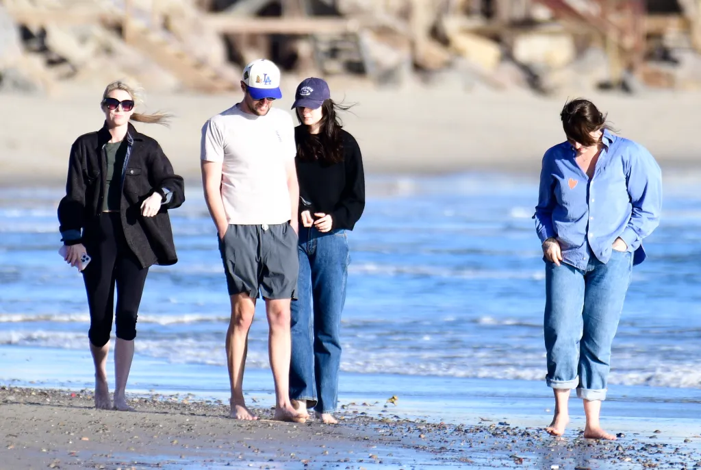 Romy Reiner and Jake Reiner walk along the beach with Jake's girlfriend and a friend in Malibu, California.