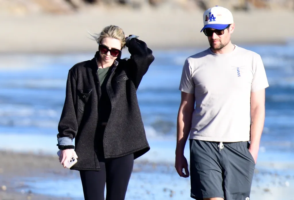 Romy Reiner and Jake Reiner walking on a beach.