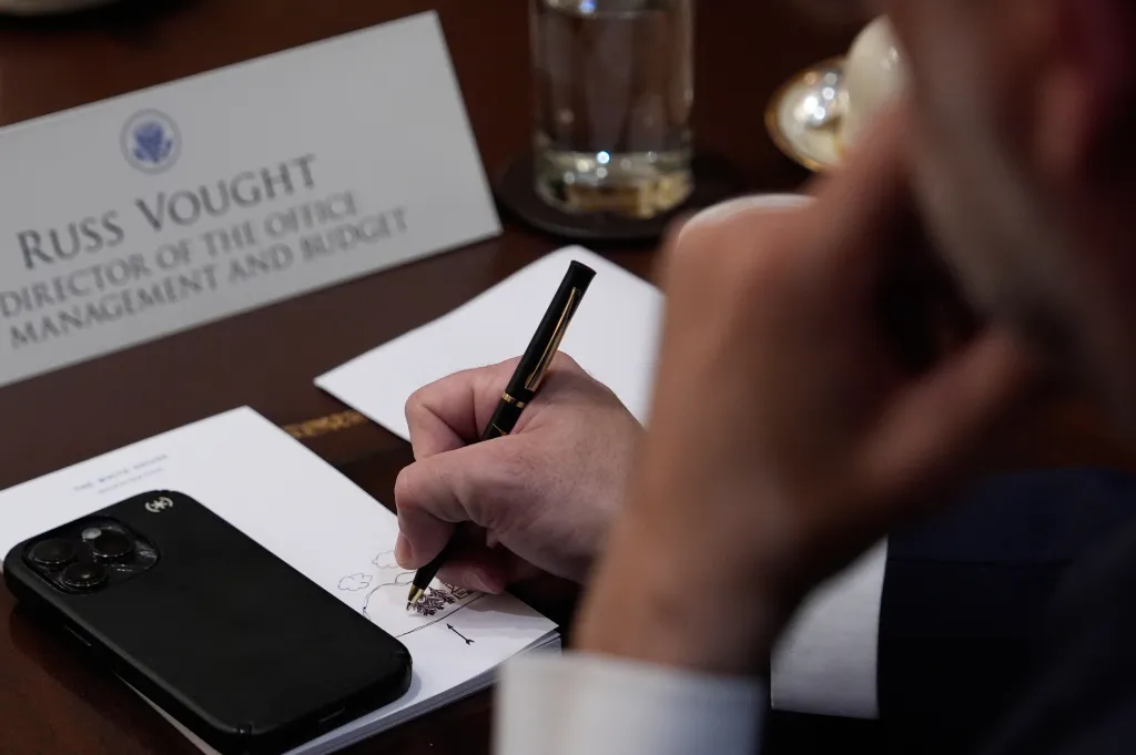 Russ Vought, Director of the Office of Management and Budget, drawing on a notepad.