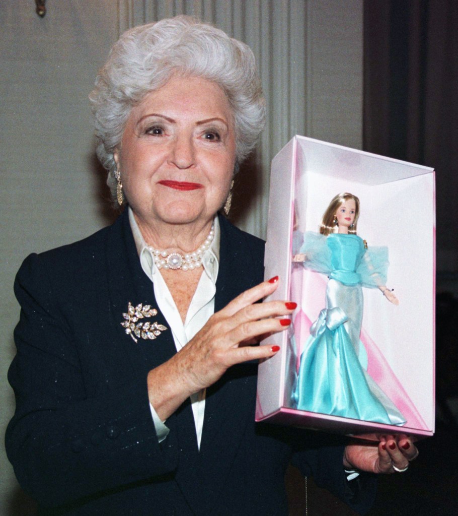 Ruth Handler, co-founder of Mattel Toys and creator of the Barbie doll, holds a boxed Barbie doll wearing a blue dress.