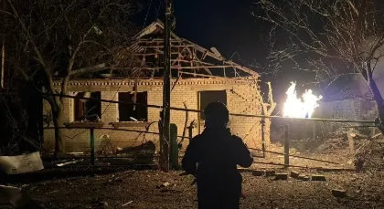 Damaged building with a collapsed roof and fire after a strike in Ukraine.