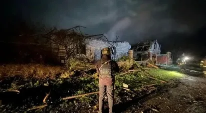 Man stands before a destroyed building in Donetsk region, Ukraine.