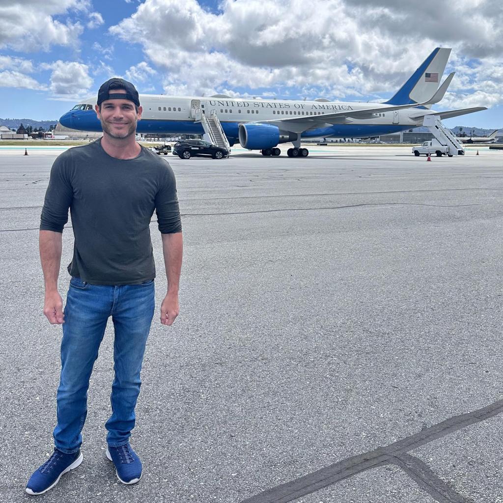 Chad Spodick poses in front of a plane.