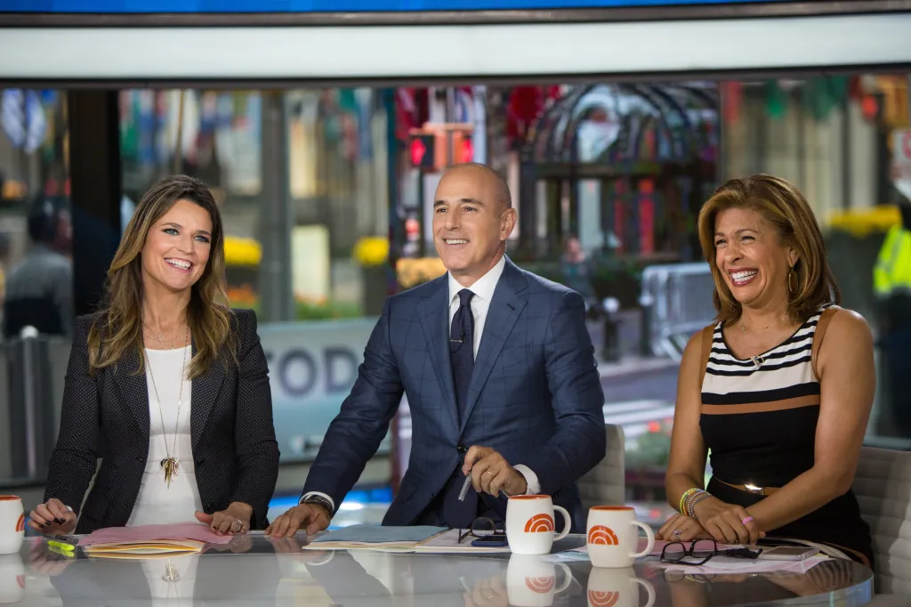 Savannah Guthrie, Matt Lauer, and Hoda Kotb smiling on the TODAY set.
