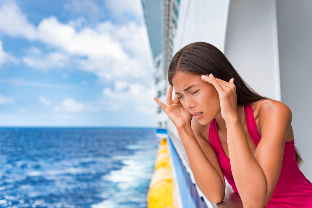 Woman on a cruise ship experiencing motion sickness or a migraine.