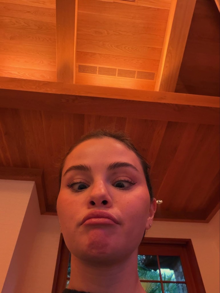Selena Gomez making a funny face, crossing her eyes and pouting.