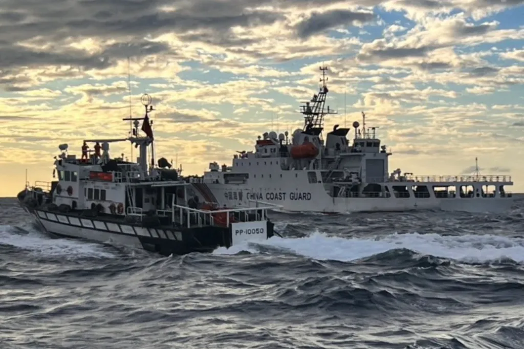 a Taiwanese coast guard ship (L) sending warnings to a Chinese coast guard ship in the waters off Taiwan's Cape Fugui. China's military drills around Taiwan entered their second day on December 30