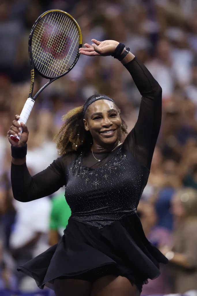Serena Williams celebrates with her racket raised overhead after winning a match at the 2022 US Open.