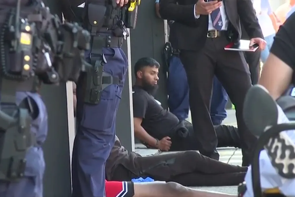 Handcuffed men on the ground surrounded by police officers during an arrest operation.