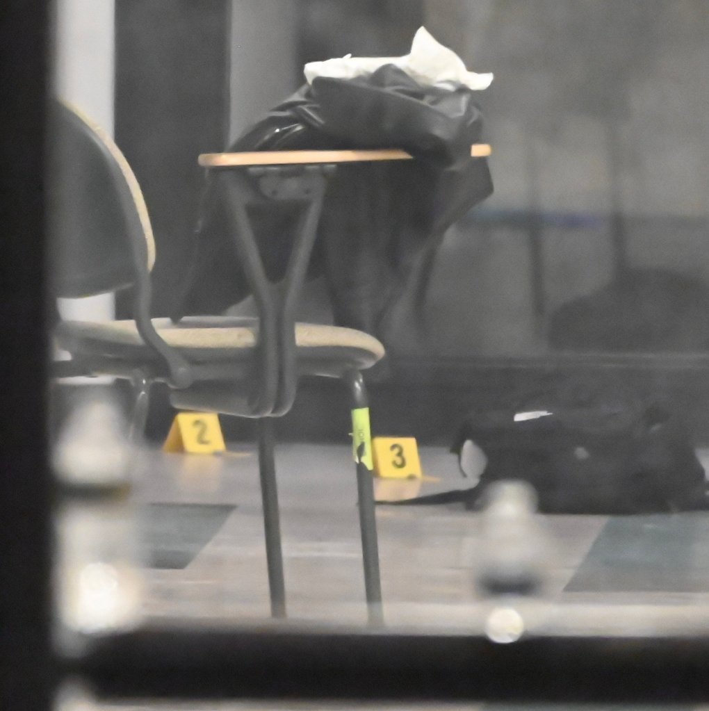 Shell casings marked with evidence markers on a floor at Brown University after a mass shooting.