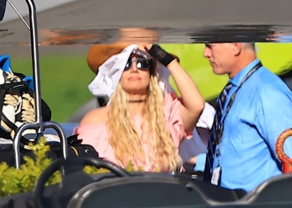 Britney Spears shields her face with a white cloth while stepping off a private jet.