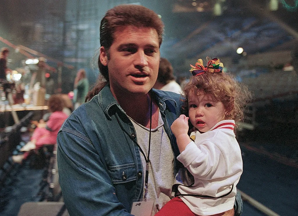 Singer-songwriter Billy Ray Cyrus holds his daughter Miley Cyrus.