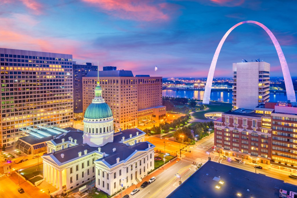 St. Louis, Missouri skyline at dusk with the Gateway Arch, Old Courthouse, and other city buildings.