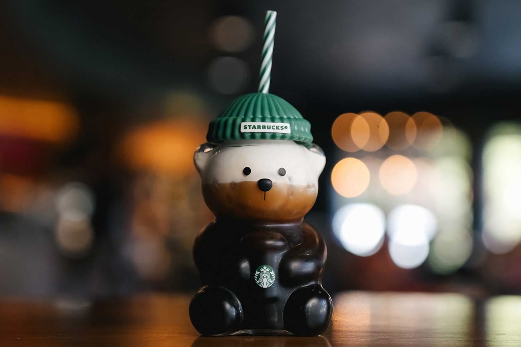 A Starbucks Bearista Cold Cup filled with a layered cold coffee drink.