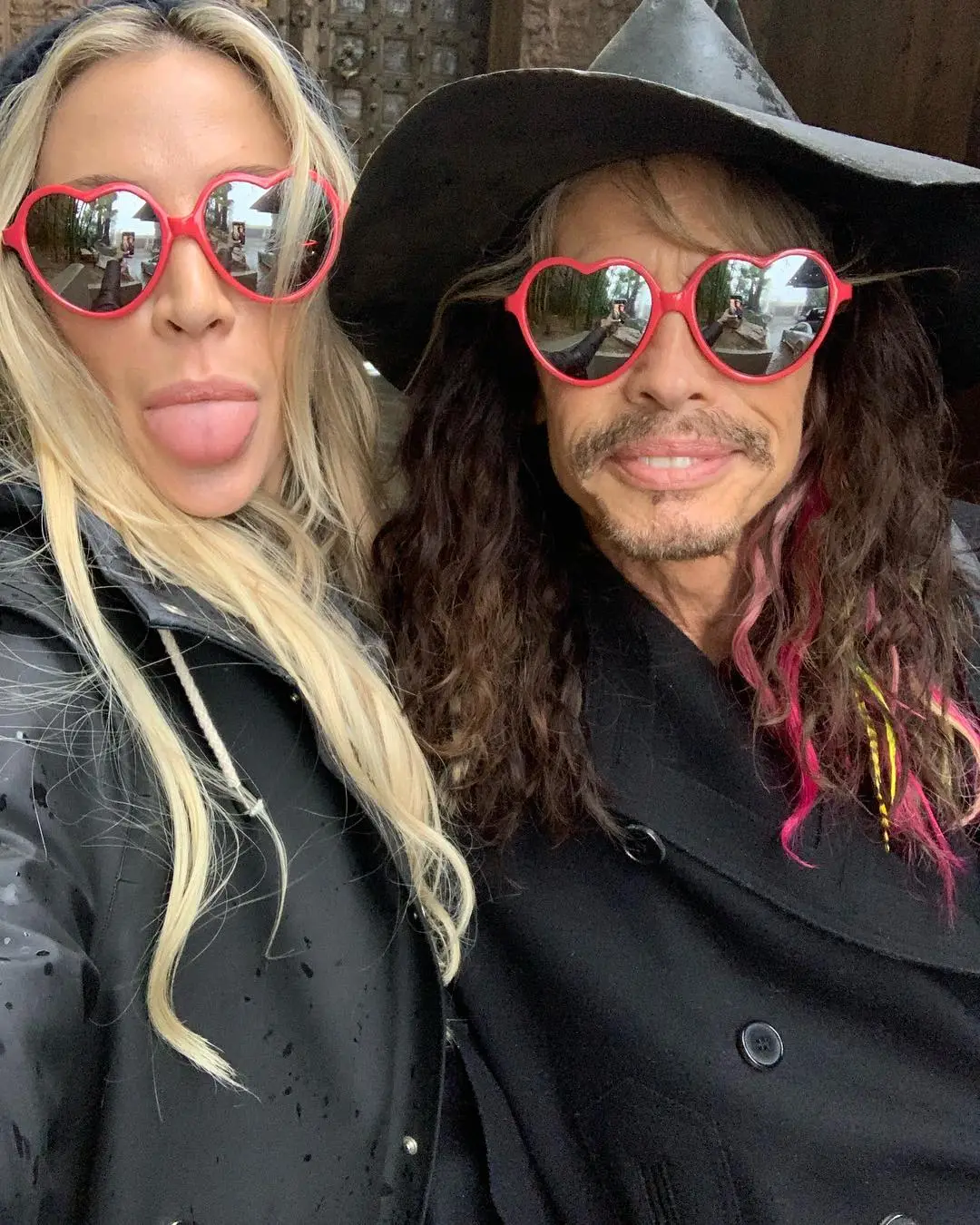 Steven Tyler and Aimee Preston wearing heart-shaped sunglasses.