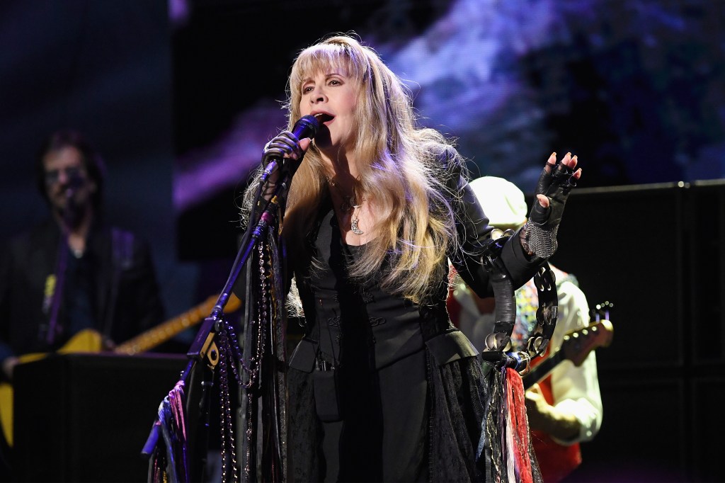 Stevie Nicks performing on stage with a microphone.