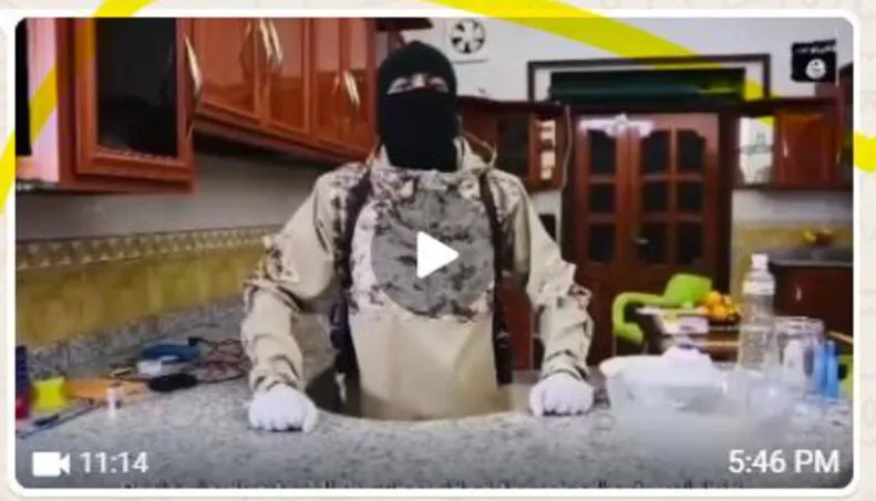 Still photo from a video depicting a masked and gloved individual prepared to assemble materials.