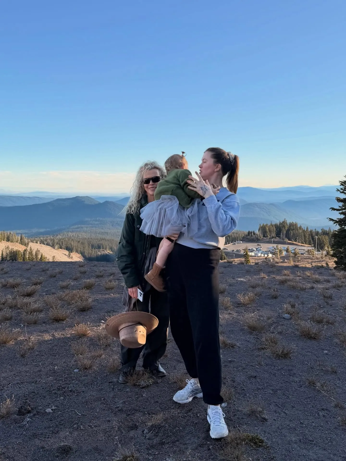 Kim Basinger, Ireland Baldwin, and Holland in a photo, with mountains and trees in the background.